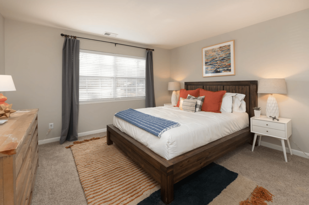 A furnished bedroom in Charlottesville with a bed and a dresser. | Spark Living